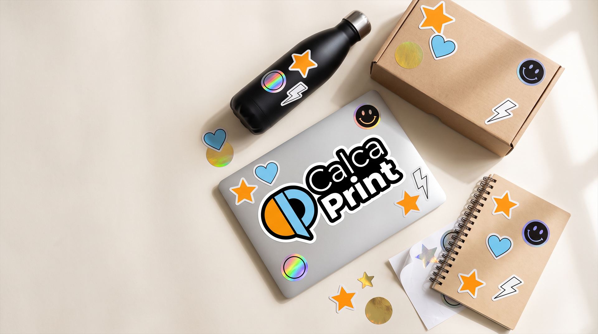 Portátil, termo, caja y libreta decorados con stickers troquelados, uno con el logo de Calcaprint